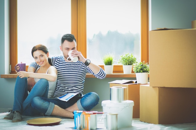 Portrait glücklich lächelnde junge Paar Malerei Innenwand des neuen Hauses junges Paar