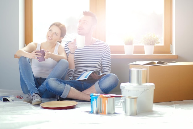 Portrait glücklich lächelnde junge Paar Malerei Innenwand des neuen Hauses junges Paar