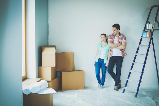 Portrait glücklich lächelnde junge Paar Malerei Innenwand des neuen Hauses