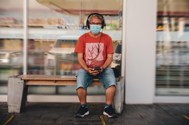 Foto portrait in voller länge eines jungen mannes, der auf einem sitz sitzt