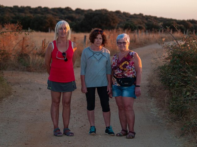 Foto portrait in voller länge von frauen, die gegen bäume und den himmel stehen