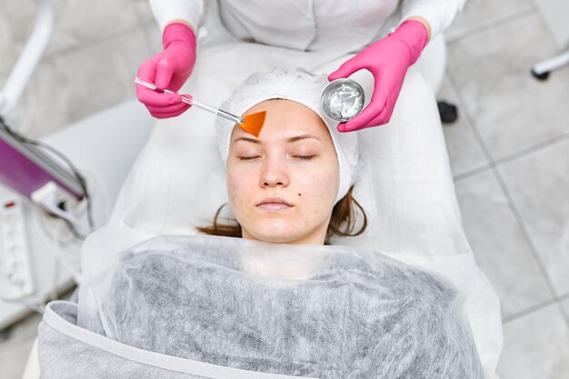 Portrait Kosmetikerin, die im Spa-Salon eine Maske auf das Gesicht des Kunden aufträgt. Wellness-Center Beruf im Gesundheitswesen