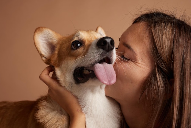 Foto portrait of a girl and a corgi dog on a clean beige background love for animals