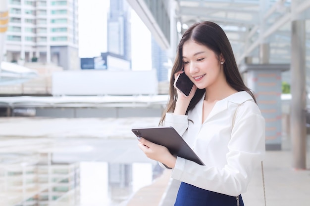 Portrait Professional Business Asiatin geht zum Büro oder Arbeitsplatz, während sie Tablet hält