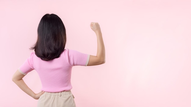 Portrait Rückseite der Frau stolz und selbstbewusst zeigt starke Muskelkraft Arme gebeugt posieren fühlt sich über ihre Erfolgsleistung Frauen Empowerment Gleichheit gesunde Kraft und Mut Konzept