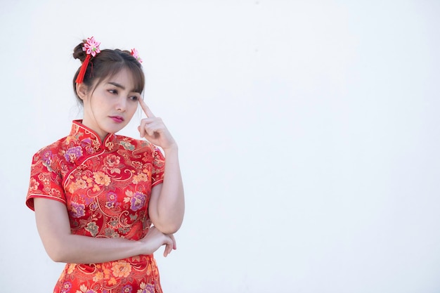 Portrait schöne asiatische Frau in Cheongsam-Kleid auf weißem HintergrundThailänderHappy Chinese New Year conceptHappy asiatische Dame in traditioneller chinesischer Kleidung