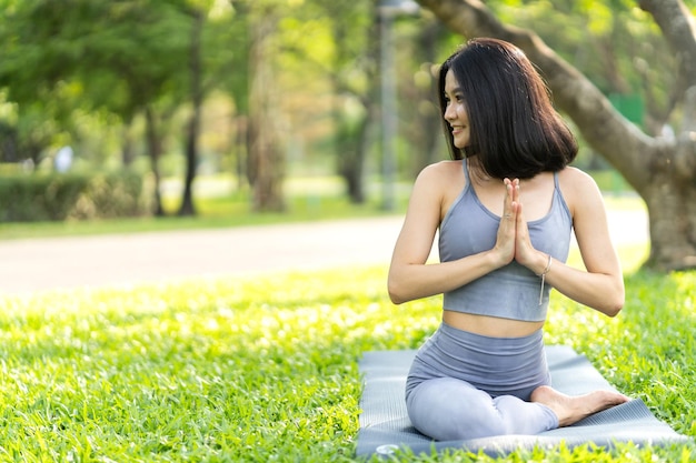 Portrait Sport asiatische Schönheit Körper schlanke Frau in Sportkleidung sitzend entspannen und Mädchen Yoga praktizieren und Fitnessübungen im Park zu Hause machenDiätkonzeptFitness und gesund