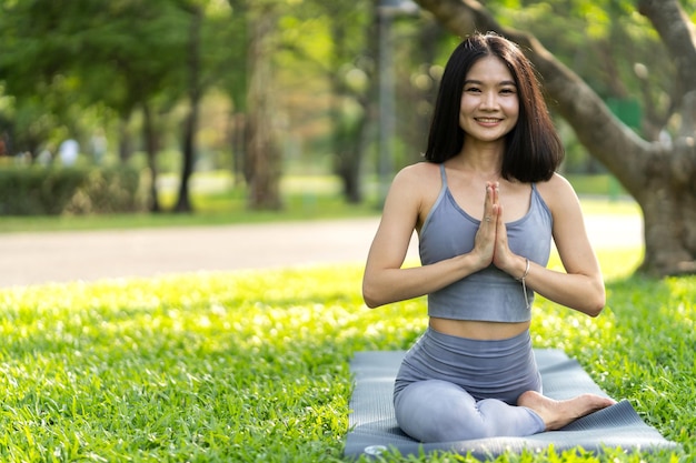 Portrait Sport asiatische Schönheit Körper schlanke Frau in Sportkleidung sitzend entspannen und Mädchen Yoga praktizieren und Fitnessübungen im Park zu Hause machenDiätkonzeptFitness und gesund