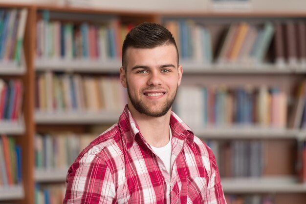 Portrait von cleveren kaukasischen Studenten in der College-Bibliothek, geringe Schärfentiefe