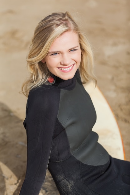 Portrait von einem schönen blonden im Taucheranzug mit Surfbrett