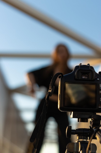 Portrait von Frau Modellierung für eine Kamera auf einem Stativ montiert Frau auf einer Brücke posiert für eine Kamera