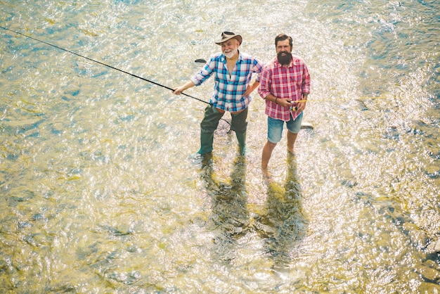 Portrait von fröhlichen senior Mann Angeln Großvater und Sohn Fischer Junger Mann und ein alter Mann Angeln für Spinnereien auf dem Fluss oder See