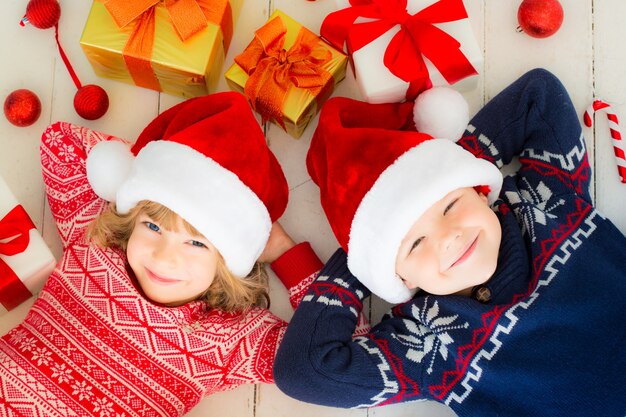 Portrait von glücklichen Kindern mit Weihnachtsschmuck. Zwei Kinder haben Spaß zu Hause