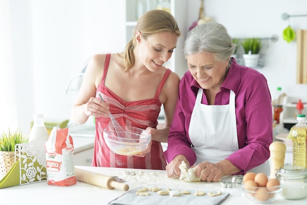 Portrait von schönen Frauen, die zu Hause in der Küche backen