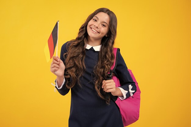 Portrait von Schulmädchen mit Rucksack halten Deutschland Flagge Bildung und Lernen in Deutschland