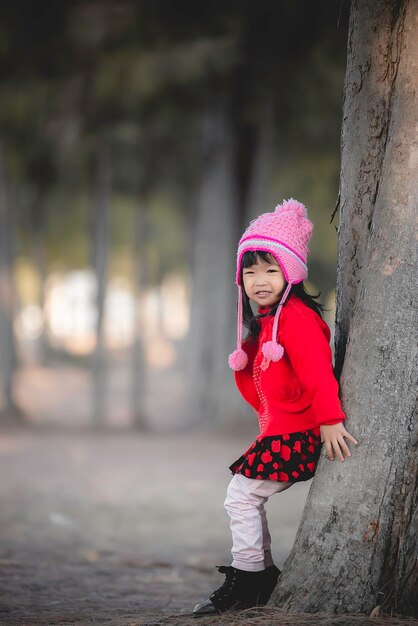 Portrait von süßen asiatischen kleinen Mädchen tragen Winterkleidung im Wald des ParksThailänder posieren für ein FotoGlückliche Zeit