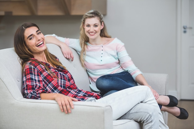 Portrait von zwei schönen Frauen, die auf Sofa sitzen