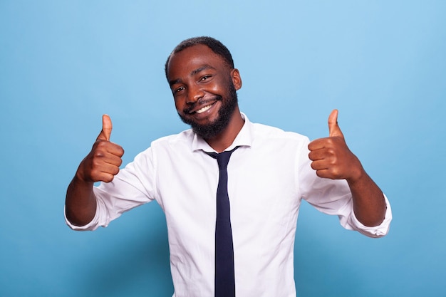 Portratit do empresário otimista sorridente dando dois polegares para celebrar o sucesso do negócio. Pessoa alegre e feliz fazendo gesto com a mão para grande realização.