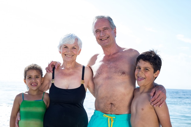 Portriat de abuelos con nietos en la playa