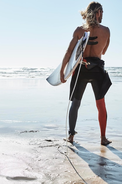 Portugal, Algarve, homem na praia com prancha de surf