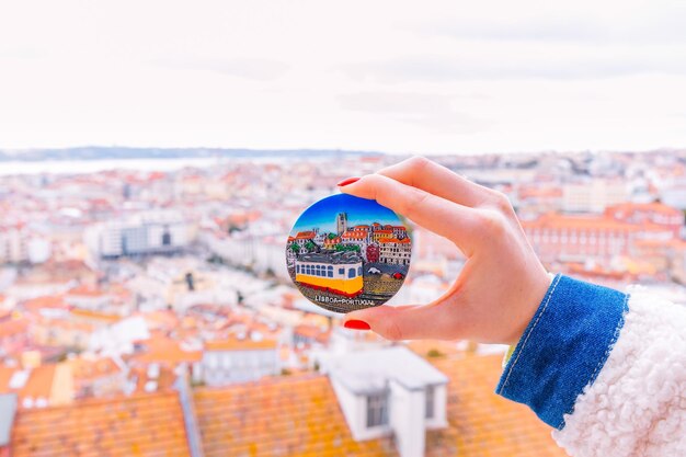 Portugal Lisboa 31 de enero de 2019 vista panorámica de la ciudad La niña sostiene un imán de regalo en el que hay una imagen de un tranvía amarillo