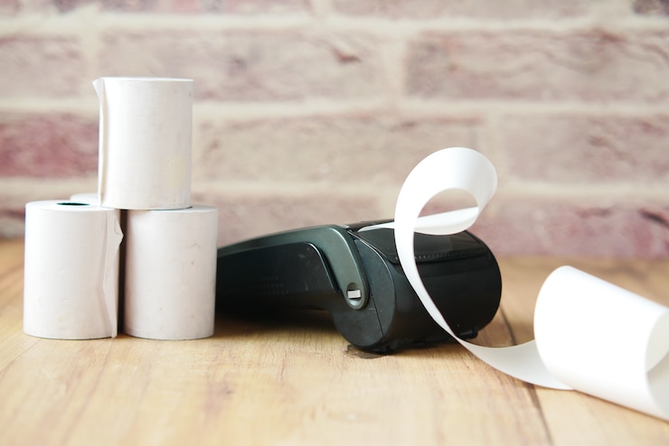 Foto pos máquina e rolo de papel longo na mesa