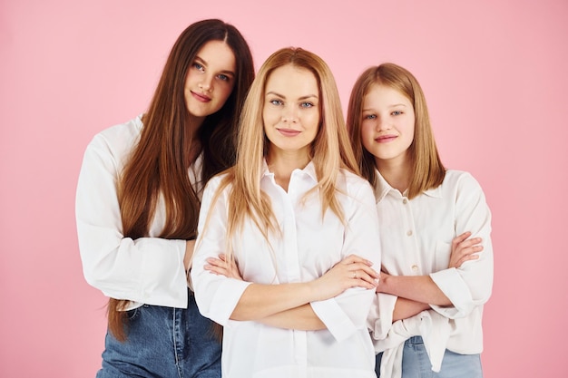 Posando para una cámara Joven madre con sus dos hijas está en el estudio