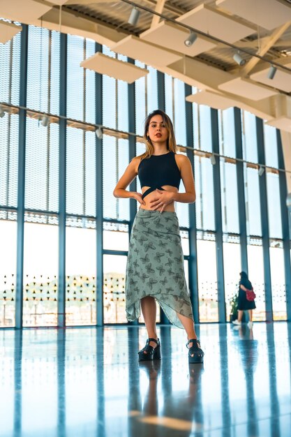 Posando de um terraço feminino de um ponto de vista da cidade em um prédio de vidro