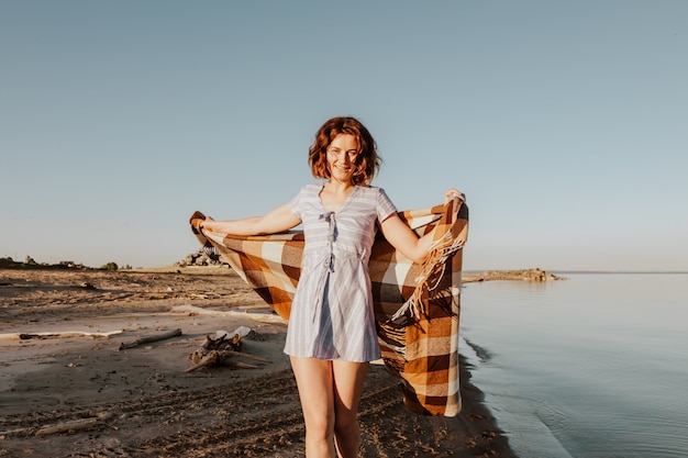 Posando mulher na natureza. Jovem mulher de vestido azul com uma manta posando e andando