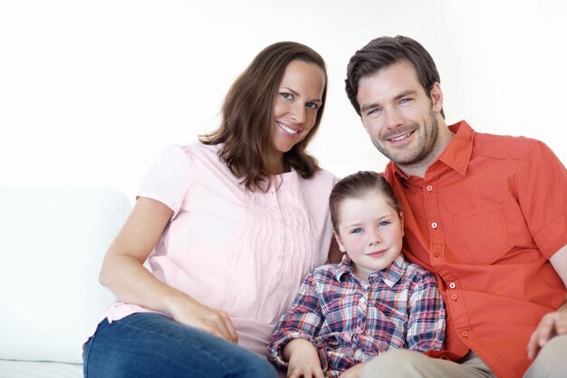 Foto posando para un retrato familiar retrato de una familia joven de tres personas sentada en el sofá de la sala