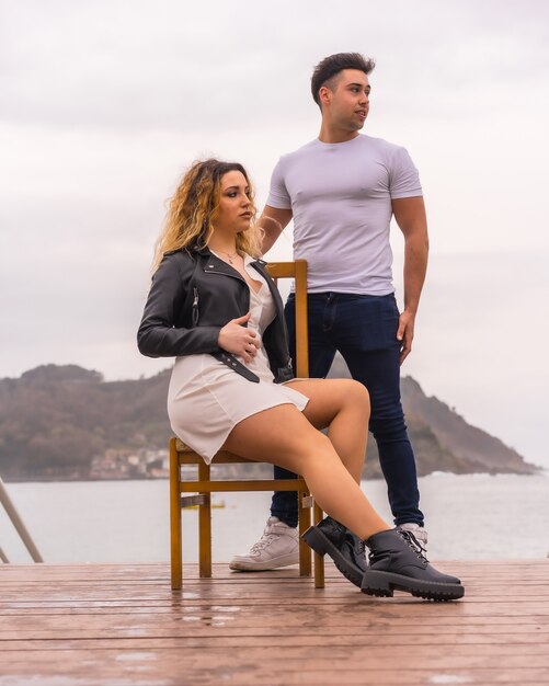 Pose de moda de una pareja caucásica de vacaciones junto al mar.