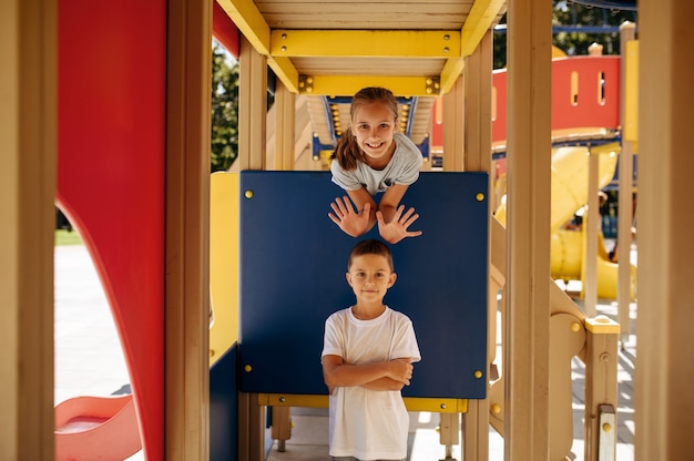 Foto poses de crianças engraçadas no parque de corda, playground. crianças subindo em ponte suspensa