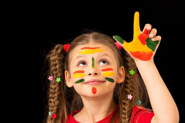 Poses de una niña manchada con pintura.