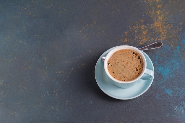 Posição plana de café preto com espuma em uma xícara