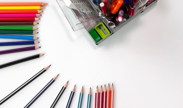 Posición de lápices de color creativos con elementos educativos en fondo blanco utilizados en el concepto de Regreso a la escuela Vista superior de lápices multicolores aislados en fondo blanco