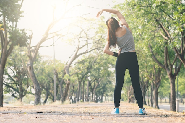 Posición de la yoga de la mujer de la aptitud derecha en la calle.