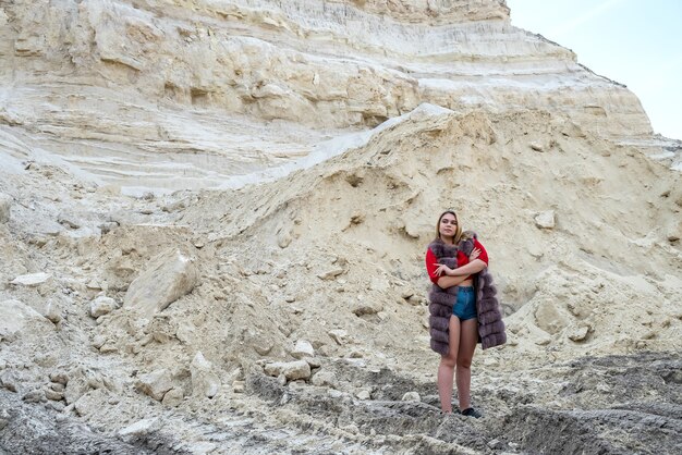 Posign de mujer de moda joven en montañas de arena