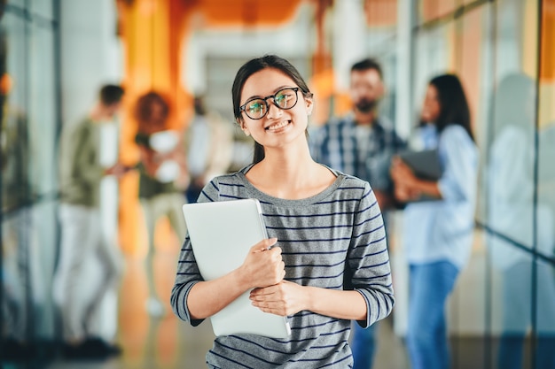 Posint joven emocionada con otras personas en segundo plano.