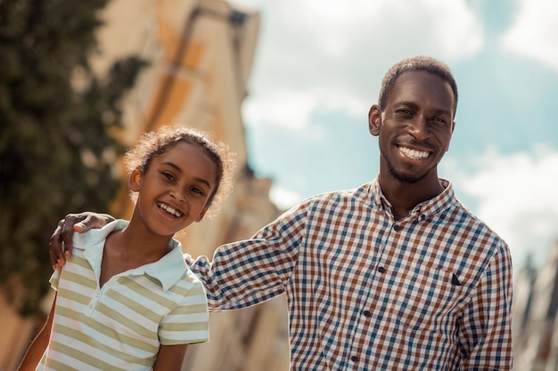 Positiv erfreute internationale Familie, die in die Kamera schaut