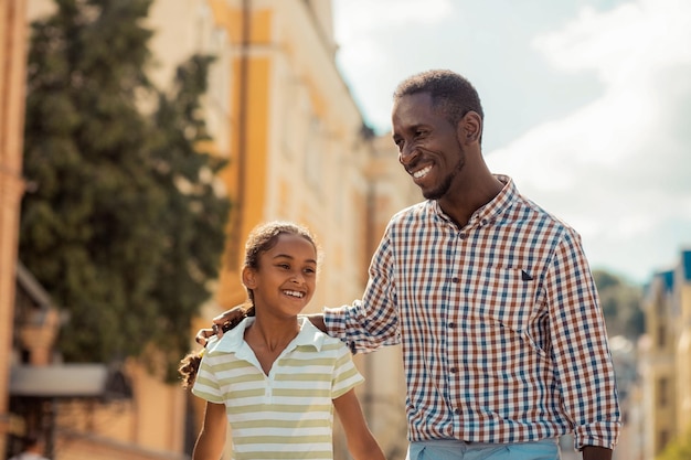 Positiv erfreute internationale Familie, die zusammen Urlaub verbringt