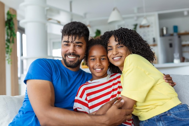 Positiva alegre família multiétnica esposa marido filho sentado juntos no sofá em casa Close up foco em filha pequena e bela mãe feliz conceito de família multirracial