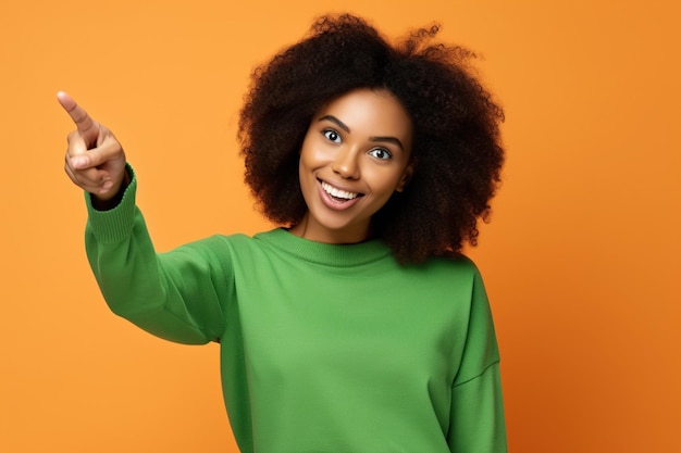 Foto positiva emocionada mujer afroamericana usar camisa verde mirando hacia el espacio vacío aislado fondo de color naranja