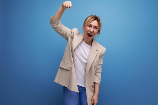 Positive blonde junge Frau im lässigen Stil auf Studiohintergrund