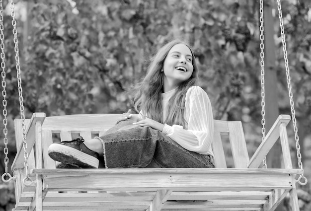 Positive Emotionen frohes Kind auf Schaukel Kind schwingt Outdoor-Teenager-Mädchen, das Spaß hat