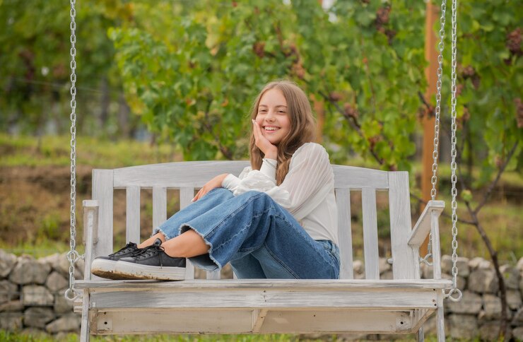 Positive Emotionen lächelndes Kind auf Schaukel Kind schwingt Outdoor-Teenager-Mädchen, das Spaß hat