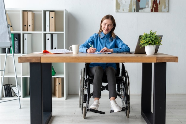 Positive erwachsene Frau, die im Büro arbeitet