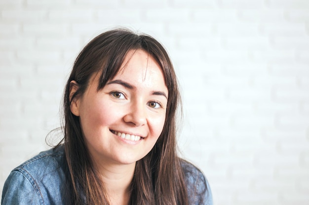 positive frau, die auf einem hellen hintergrund lächelt