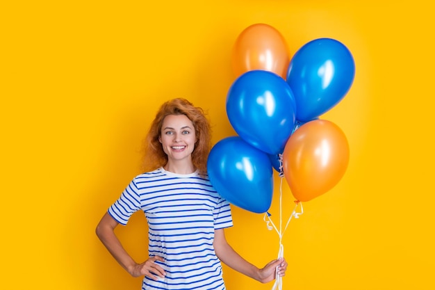 Positive Frau hält Party-Ballons im Studio Frau mit Ballon für Party isoliert auf gelbem Hintergrund Party-Frau mit Ballon