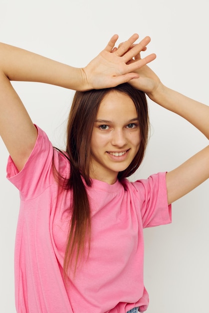 Positive Frau in einem rosa T-Shirt Freizeitkleidung rosa Hintergrund