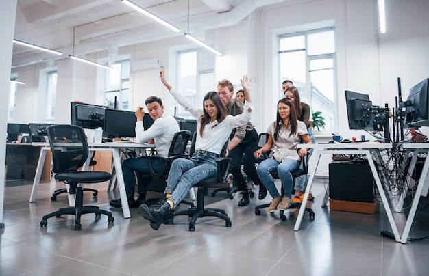 Positive junge Leute haben Spaß in der Pause im Büro.